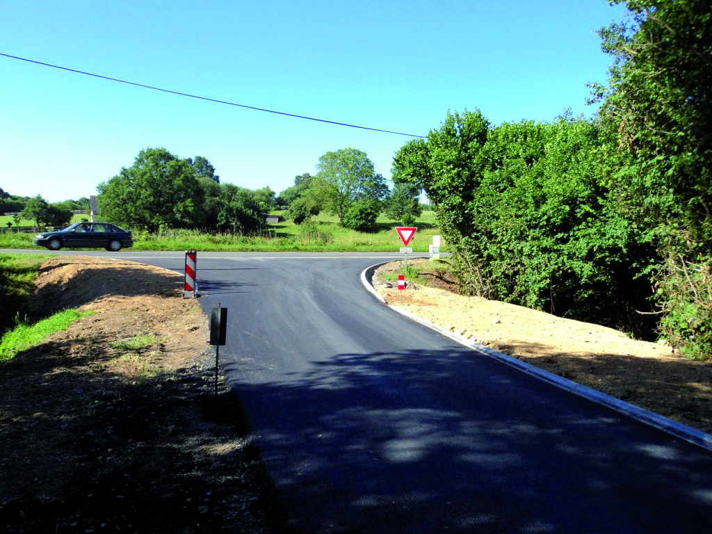 Route de campagne en enrobé neuf bordée de talus