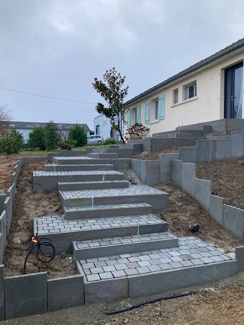 Escalier extérieur en pavés et bordures de schiste sur un terrain en pente