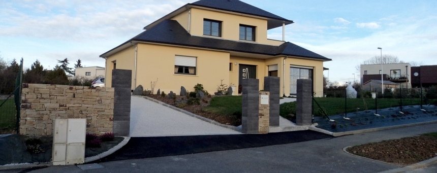 Muret en pierre et piliers en ardoise à l'entrée d'une maison