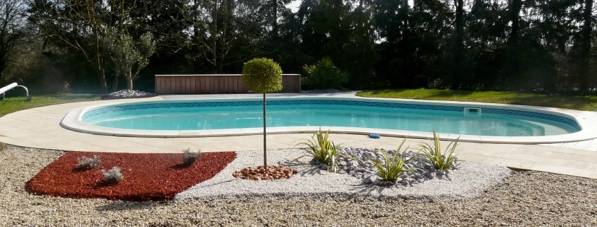 Piscine entourée d'une plage minérale et de massifs plantés