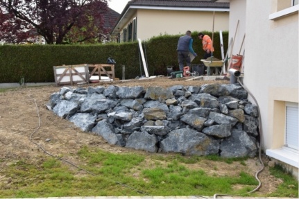 Enrochement en blocs de granit stabilisant un talus devant une maison au Bourgneuf-la-Forêt