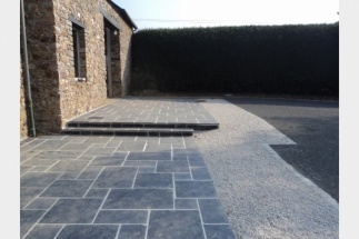 Terrasse en dalles d'ardoise avec marches, au pied d'une maison en pierre