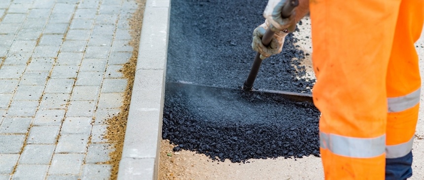 Application d'un enrobé à la main le long d'une bordure et d'un pavage
